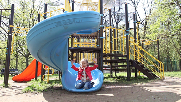 Adorable Little Girl Riding On a Slide