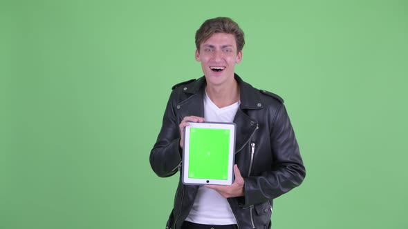 Happy Young Rebellious Man Showing Digital Tablet and Looking Surprised