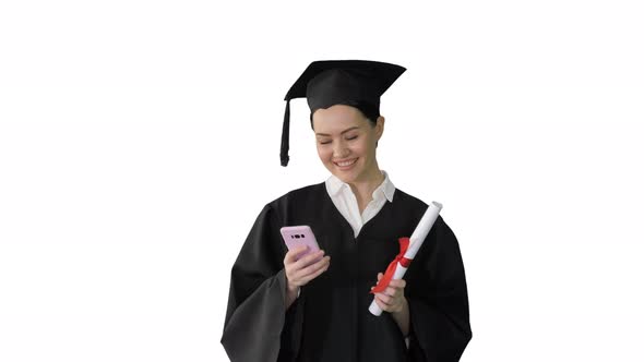 Happy Female Graduate Holding Diploma and Texting on Her Phone on White Background.