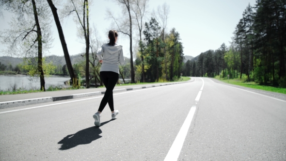 Female Runner Jogging On Mountain Road Training For Marathon.