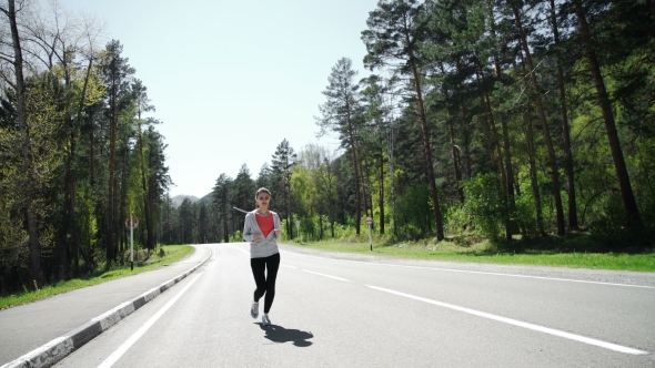 Female Runner Jogging On Mountain Road Training For Marathon.