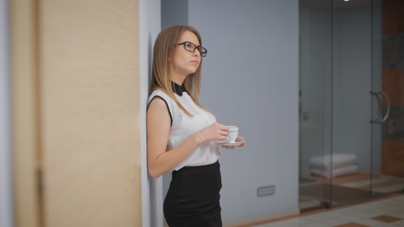 Young Girl In The Corridor With Coffee In Hand
