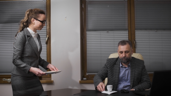 Young Secretary Servicing The Coffee To Her Handsome Boss