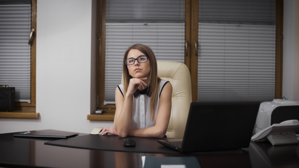 Secretary Girl Distracted From Work. She Sits At a Desk And Dreaming Of Vacation. 