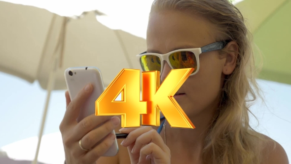 Woman In Sunglasses Using Cell On Beach