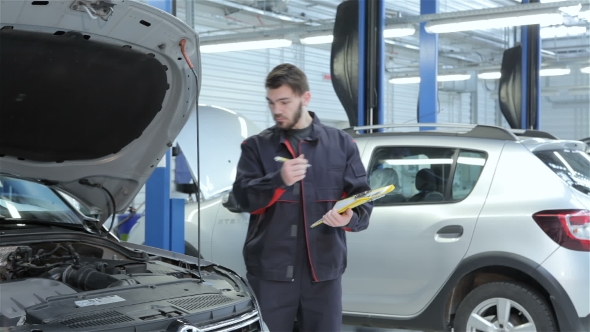 Mechanic Examines Car At The Service