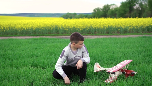 Cute Boy With Homemade Helicopter Sitting On The Wheat And Looks On The Sky. 