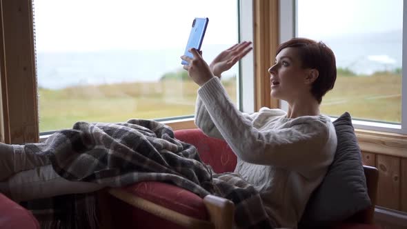 Smiling Young Woman is Making Online Video Call Looking at Smartphone Screen