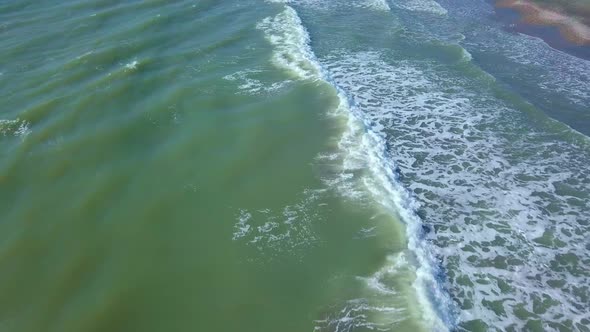 Drone view of the beautiful waves on the sandy beach,