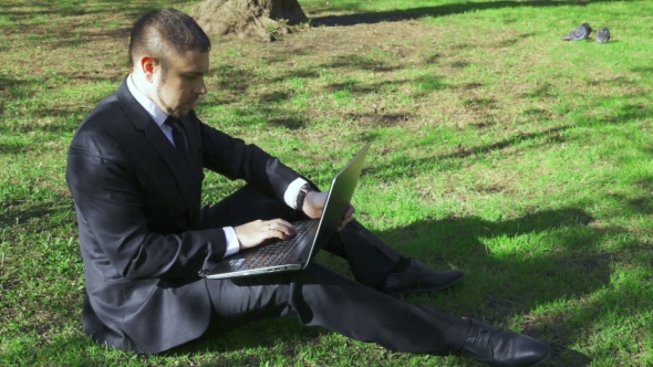 Businessman Works With Laptop In The City Park