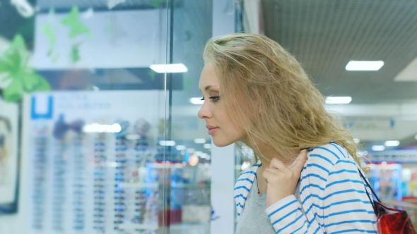 An Attractive Woman With Shopping Bags Dyal Looking In a Shop Window