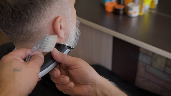 Barber Trimming Beard To His Client