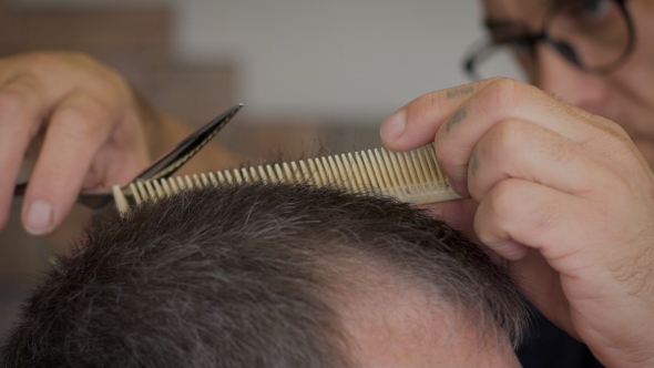 Gray-haired Man In a Barber Shop. Stylish Barber Strizhot Client Using a Comb And Scissors.