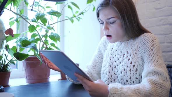 Reaction to Loss By Woman Using Tablet in Bedroom