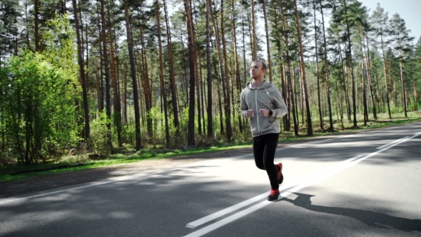 Man Running Looking At His Pulse Outside In Nature On Road With Smartwatch.