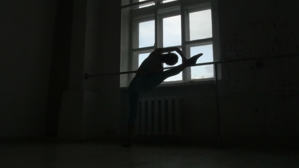 Silhouette Of a Ballet Dancer Exercising At The Barre By The Window