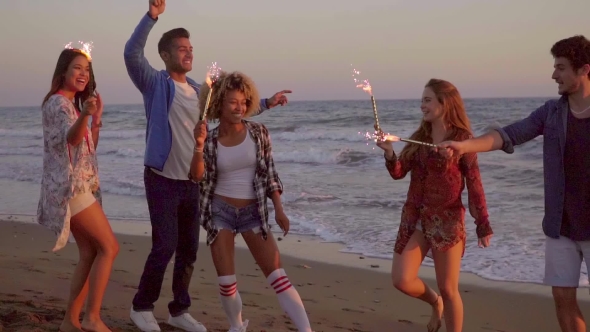 Young People With Fountain Candles On The Beach