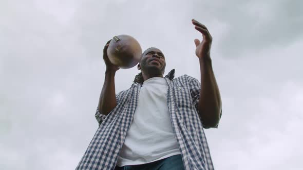 Black American Football Player Throwing Ball on Green Field
