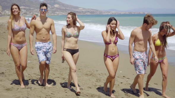 Group Of Friends Walking Together On Sunny Beach