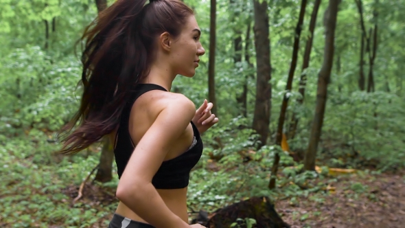 Young Athletic Sporty Girl With Long Hair Training In Green Forest 
