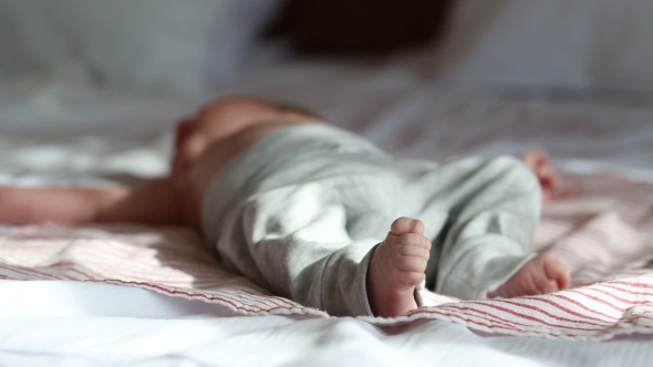 Newborn Baby Lying On a Bed