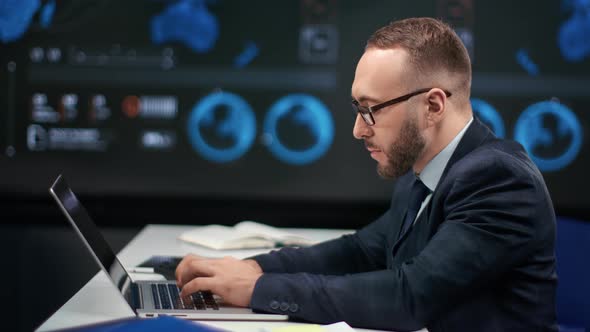 Male Financial Trader Working Use Laptop at Global Stock Exchange