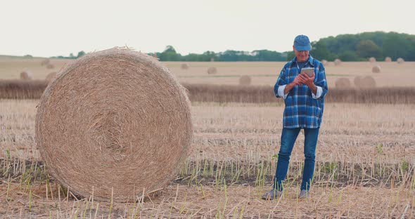 Farmer Using Digital Tablet While Examining Field