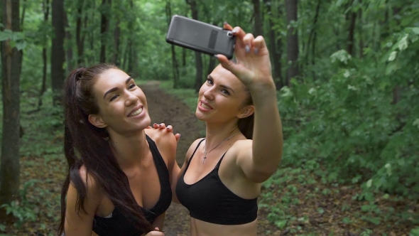 Beautiful Girls Taking a Selfie With a Smart Phone Before Going For a Run Outdoors. 