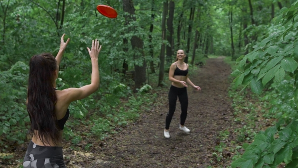 Two Slender Brunette In The Woods, Throwing a Frisbee Plate