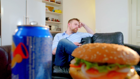 Man Watch TV and Take Hamburger and Cola at Home