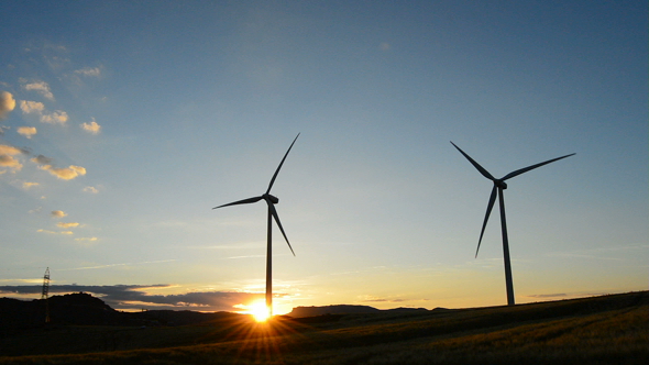 Towers of Wind Turbine Moving at Sunset