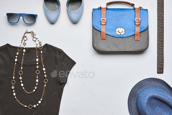 pster, stylish handbag, black top glamor shoes trendy necklace blue hat and sunglasses.Unusual urban summer outfit. Overhead, top view gray background