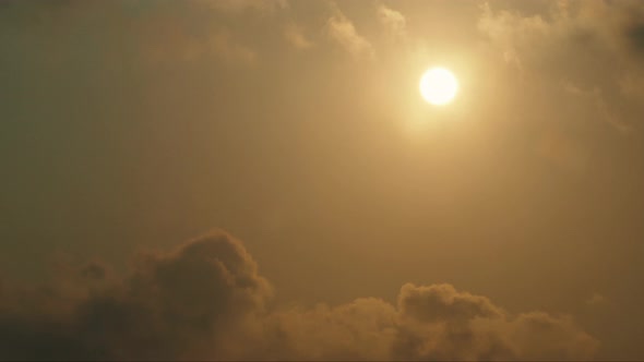 Sun rising behind moving clouds time lapse