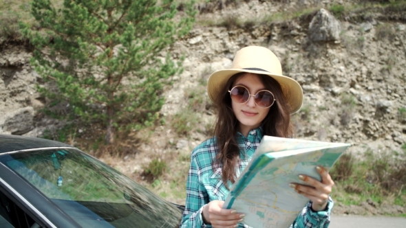 Travel - Young Woman With Car Look At Road Map On a Beach Against Sea And Sky