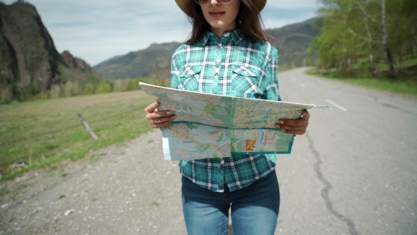 Happy Young Woman Holding Map On Road