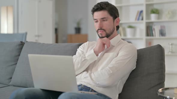 Businessman Thinking and Working on Laptop at Home