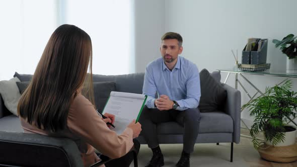 Unfocused Smiling Man Patient with Mental Health Problems Talking to Therapist
