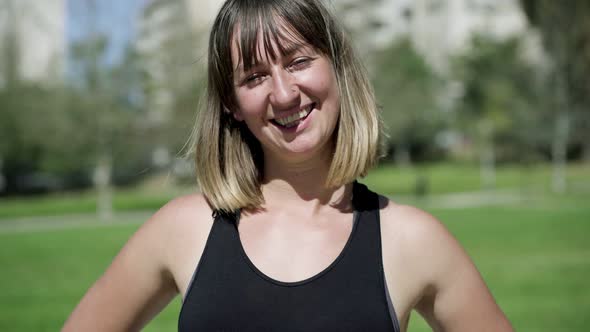 Cheerful Fit Young Woman in Sporty Sleeveless Shirt