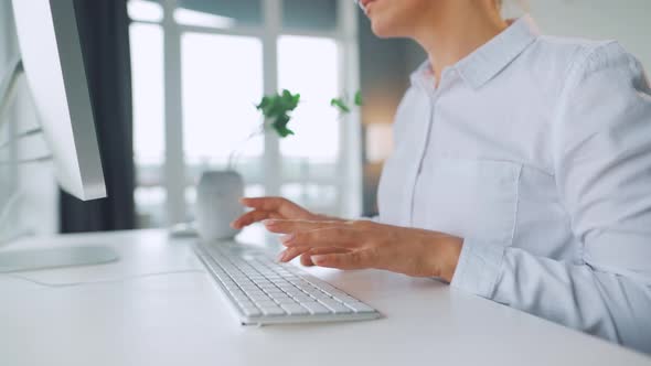 Woman with Glasses Typing on a Computer Keyboard