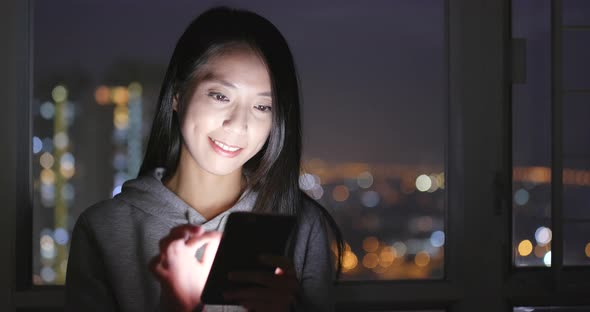 Woman use of cellphone at home in the evening