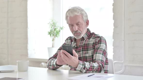 Casual Old Man Using Smartphone in Modern Office