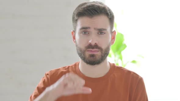 Thumbs Down Gesture By Young Man