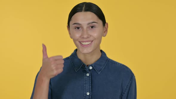 Latin Woman with Thumbs Up, Yellow Background 