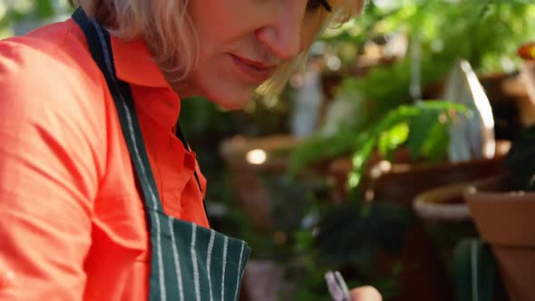 Mature woman writing on clipboard