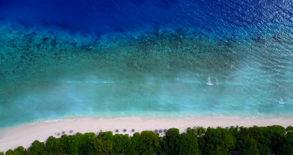 Natural overhead tourism shot of a white sand paradise beach and blue sea background in colourful 4K