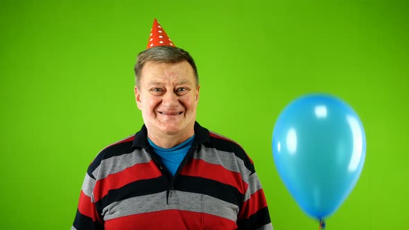 Emotional Mature Adult Man of Caucasian Ethnicity in Casual Clothes and Birthday Cap