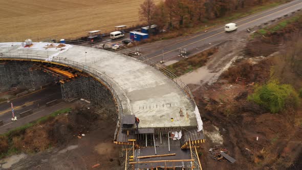 Drone Orbit Shot - a Worker Inspects the Construction of the Roadway on the Overpass 