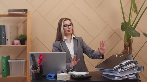 Manager is Woman Sitting at Table with Laptop and Several Folders with Documents One Folder Falls