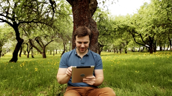 Handsome Hipster Man Using His Tablet Pc On a Sunny Day With Copy Space