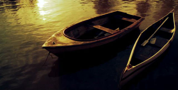 Rowboat and Canoe in Calm Water at Sunset.